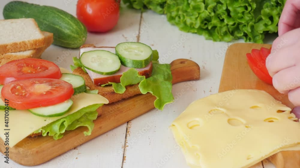 Sliced toast bread on a white plate. Fresh vegetables. Cheese and ham. 4K Sliced toast bread on a white plate. Fresh vegetables. Cheese and ham. 4K