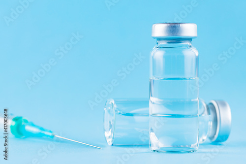 Vaccine and syringe injection. Vaccines and syringe on a blue background for prevention and immunization. Vaccine concept. Copy space