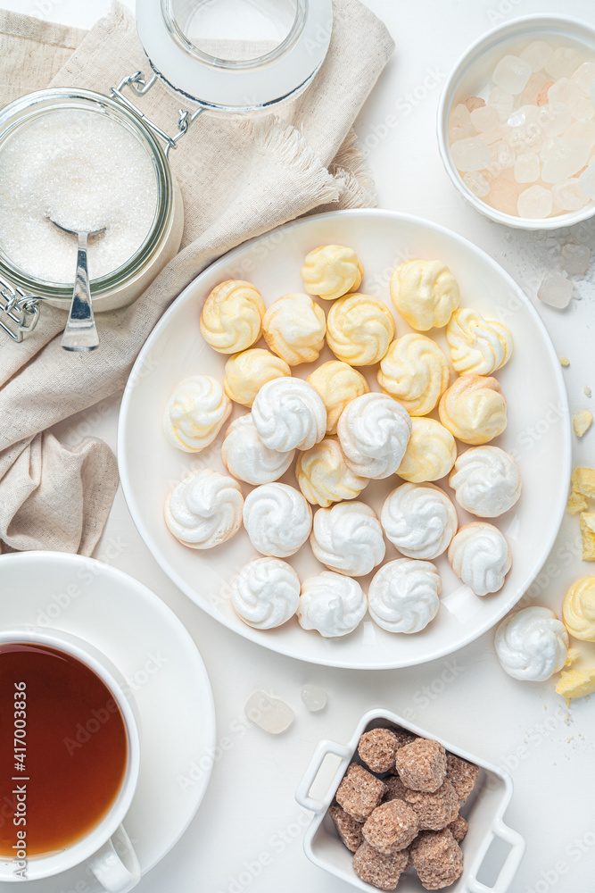 Lemon meringues and white on the background of tea, sugar on a white background. Lemon meringues and white on the background of tea, sugar on a white background.
