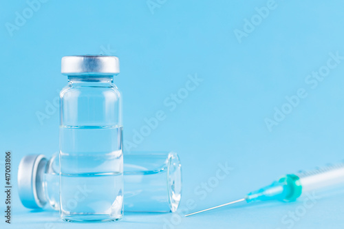 Vaccine and syringe injection. Vaccines and syringe on a blue background for prevention and immunization. Vaccine concept. Copy space