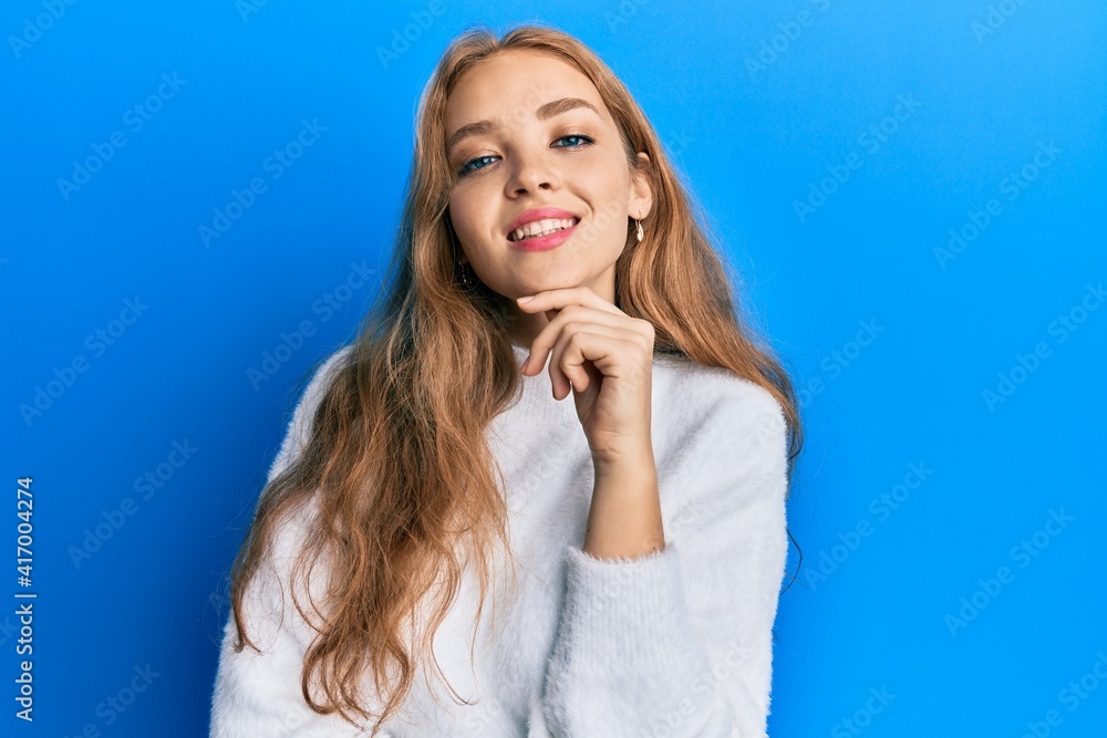 Beautiful blonde caucasian woman wearing casual winter sweater smiling looking confident at the camera with crossed arms and hand on chin. thinking positive. Beautiful blonde caucasian woman wearing casual winter sweater smiling looking confident at the camera with crossed arms and hand on chin. thinking positive.