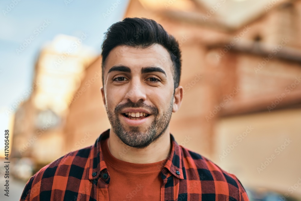 Fototapeta premium Young hispanic man smiling happy standing at the city.