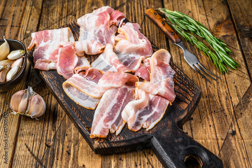 Smoked pork bacon slices on a wooden cutting board. wooden background. Top view