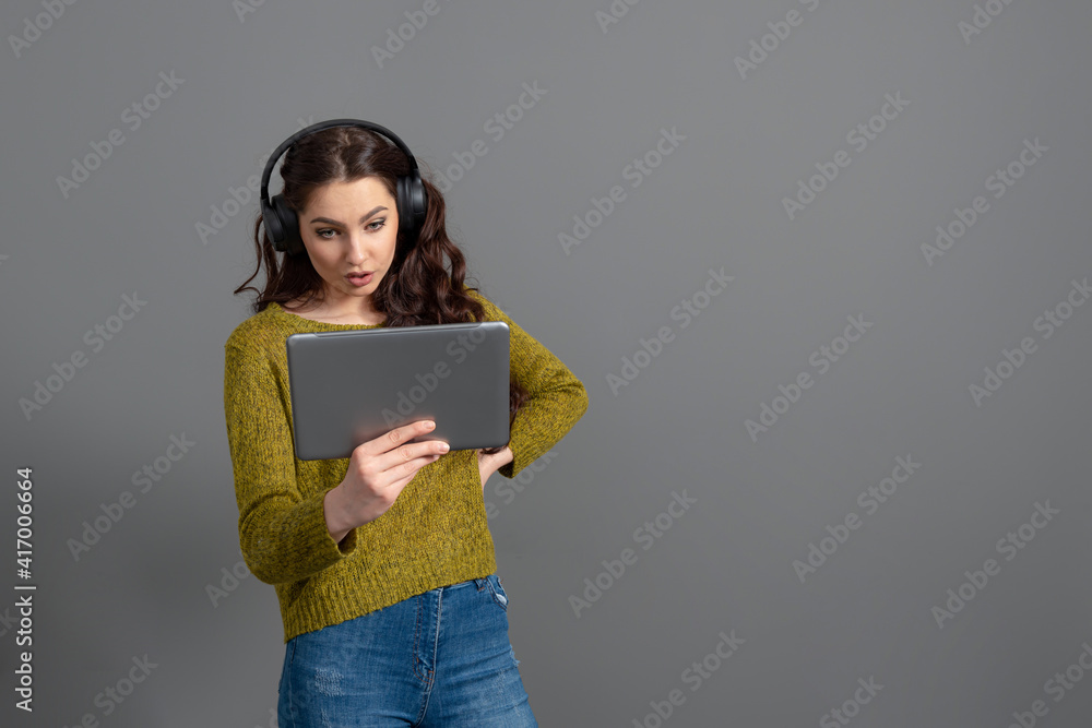 young woman with headset and tablet in hand playing games and talking to friends online young woman with headset and tablet in hand playing games and talking to friends online
