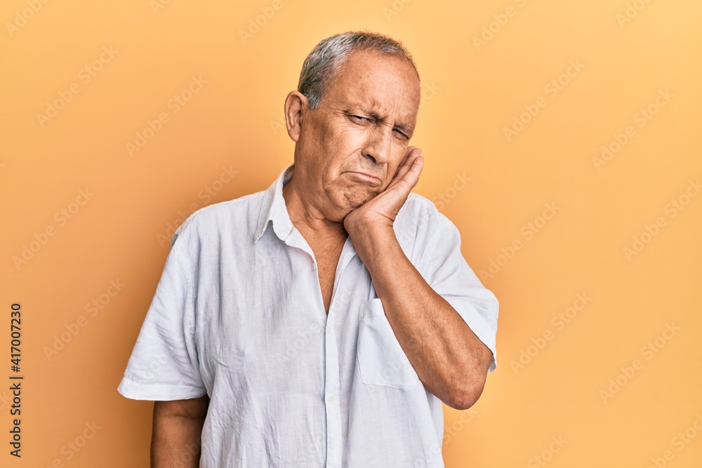 Handsome mature man wearing casual white shirt thinking looking tired and bored with depression problems with crossed arms. Handsome mature man wearing casual white shirt thinking looking tired and bored with depression problems with crossed arms.