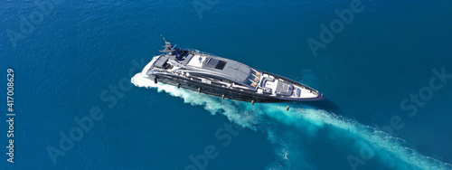 Aerial drone ultra wide photo of luxury yacht cruising in deep blue sea near Mediterranean Aegean Sea island