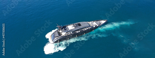 Aerial drone ultra wide photo of luxury yacht cruising in deep blue sea near Mediterranean Aegean Sea island