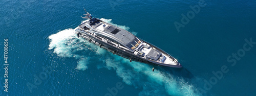 Aerial drone top view ultra wide photo of latest technology modern yacht speeding in Mediterranean port with deep blue sea
