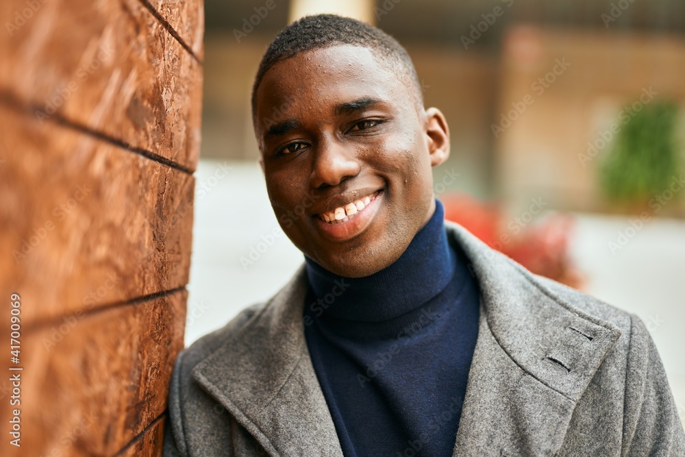 Obraz premium Young african american man smiling happy standing at the city