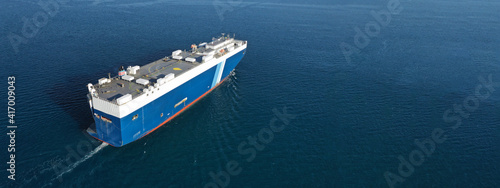 Aerial drone ultra wide photo of huge car carrier ship RO-RO (Roll on Roll off) cruising in Mediterranean deep blue Aegean sea © aerial-drone
