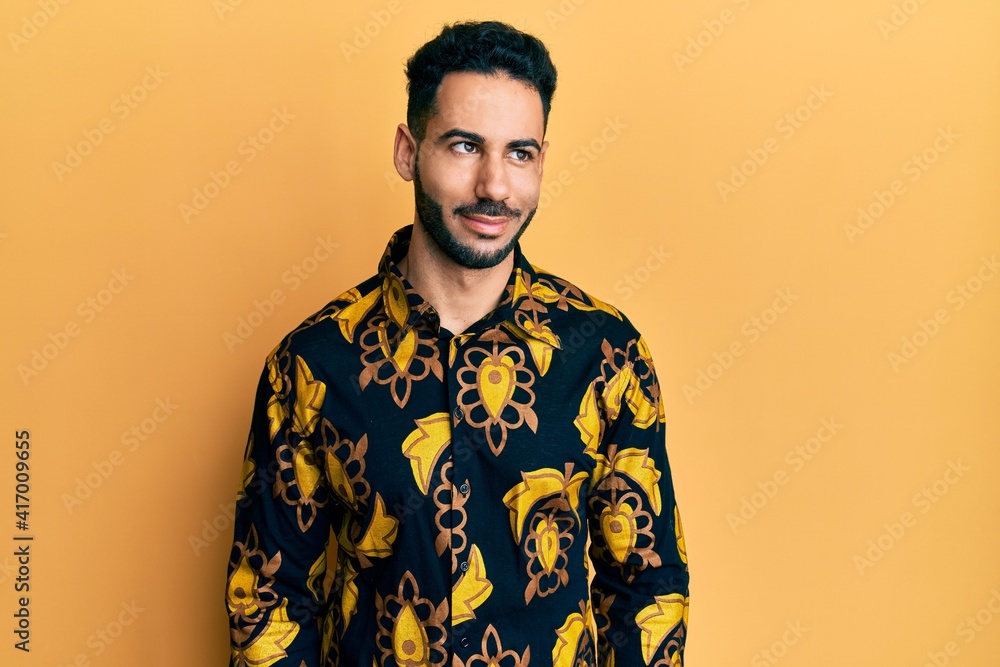 Young hispanic man wearing casual shirt smiling looking to the side and staring away thinking. Young hispanic man wearing casual shirt smiling looking to the side and staring away thinking.