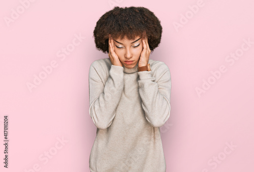 Young hispanic girl wearing wool winter sweater with hand on head, headache because stress. suffering migraine. © Krakenimages.com