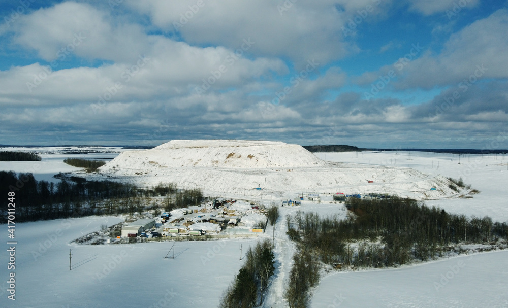 Top view of a snowy winter industrial hill in the field