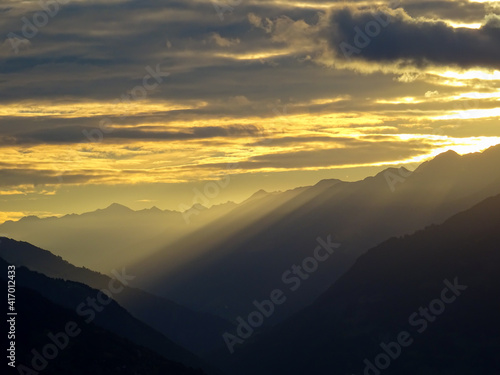 Morgensonne mit Schattenwurf durch die Berge im Goms