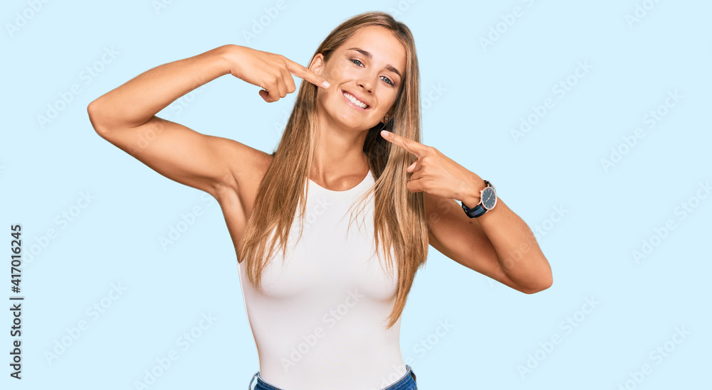 Young blonde woman wearing casual style with sleeveless shirt smiling cheerful showing and pointing with fingers teeth and mouth. dental health concept. Young blonde woman wearing casual style with sleeveless shirt smiling cheerful showing and pointing with fingers teeth and mouth. dental health concept.