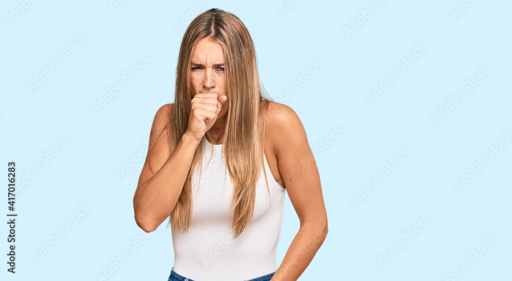 Young blonde woman wearing casual style with sleeveless shirt feeling unwell and coughing as symptom for cold or bronchitis. health care concept. Young blonde woman wearing casual style with sleeveless shirt feeling unwell and coughing as symptom for cold or bronchitis. health care concept.