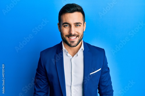 Young hispanic businessman wearing business jacket with a happy and cool smile on face. lucky person.