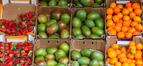 Strawberries. mangoes and tangerines for sale at a fruit shop