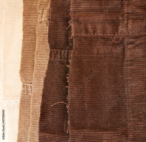 Closeup of many cotton traditional corduroy retail, with tattered around as backdrop, against white background photo