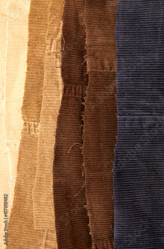 Many cotton traditional corduroy retail, with tattered around as backdrop, against white background photo