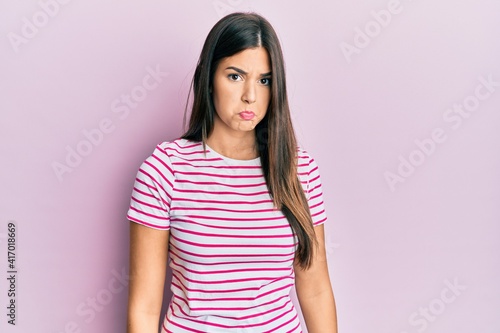Young brunette woman wearing casual clothes over pink background depressed and worry for distress, crying angry and afraid. sad expression.