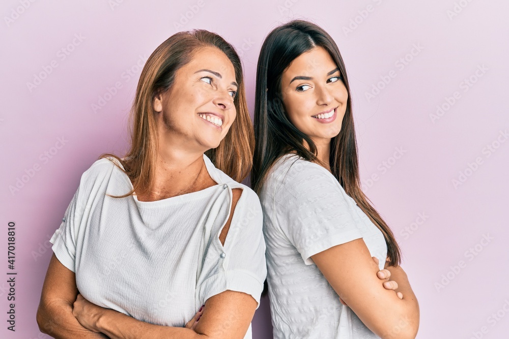 Beautiful hispanic mother and daughter smiling happy over isolated pink background. Beautiful hispanic mother and daughter smiling happy over isolated pink background.