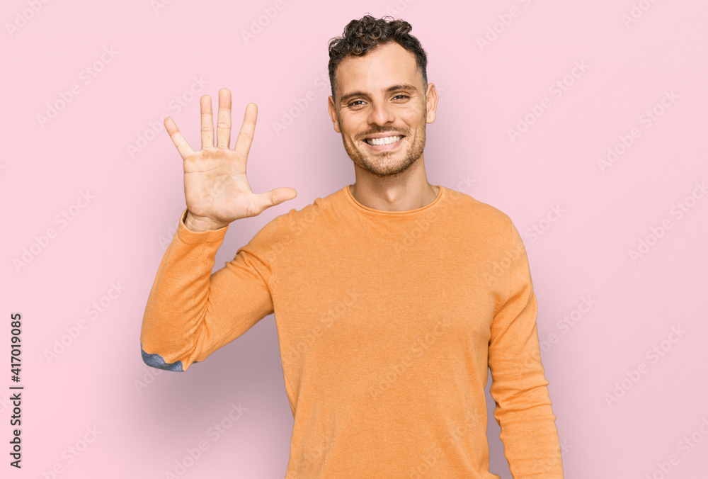Young hispanic man wearing casual clothes showing and pointing up with fingers number five while smiling confident and happy. Young hispanic man wearing casual clothes showing and pointing up with fingers number five while smiling confident and happy.