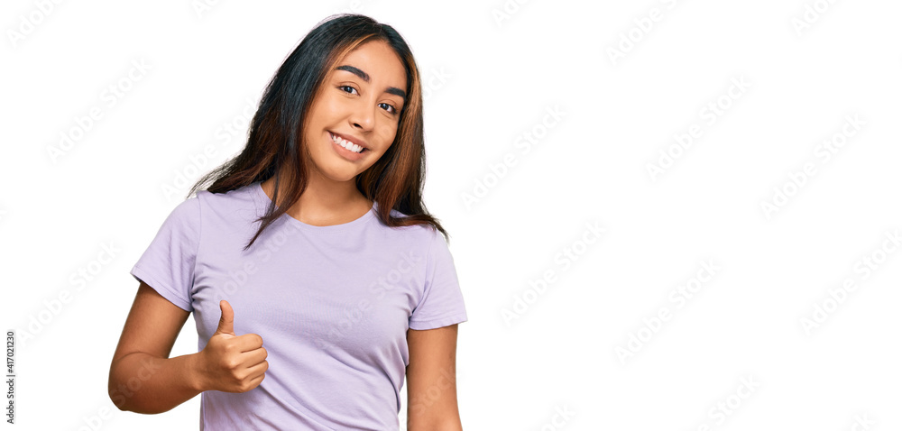 Young latin woman wearing casual clothes doing happy thumbs up gesture with hand. approving expression looking at the camera showing success. Young latin woman wearing casual clothes doing happy thumbs up gesture with hand. approving expression looking at the camera showing success.