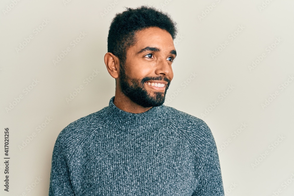 Handsome hispanic man with beard wearing casual clothes looking to side, relax profile pose with natural face and confident smile. Handsome hispanic man with beard wearing casual clothes looking to side, relax profile pose with natural face and confident smile.