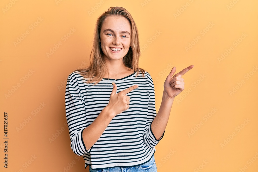 Beautiful blonde woman wearing casual clothes smiling and looking at the camera pointing with two hands and fingers to the side. Beautiful blonde woman wearing casual clothes smiling and looking at the camera pointing with two hands and fingers to the side.