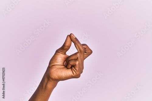 Arm and hand of black middle age woman over pink isolated background snapping fingers for success, easy and click symbol gesture with hand photo