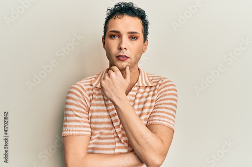 Handsome man wearing make up wearing casual shirt thinking attitude and sober expression looking self confident © Krakenimages.com