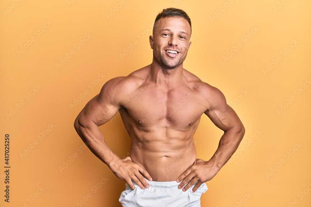 Handsome bodybuldier man posing sexy showing muscle, shirtless torso showing pectorals and sixpack