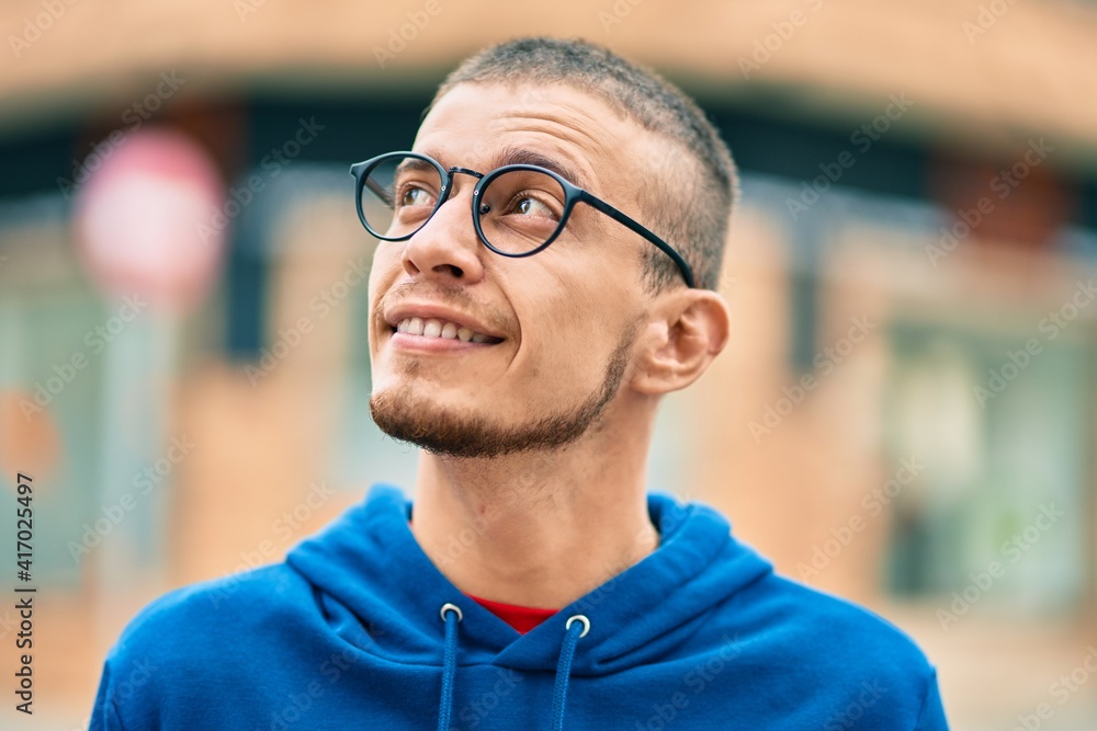 Obraz premium Young hispanic man smiling happy standing at the city.
