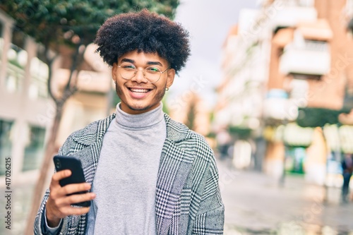 Young african american businessman smiling happy  using smartphone at the city.