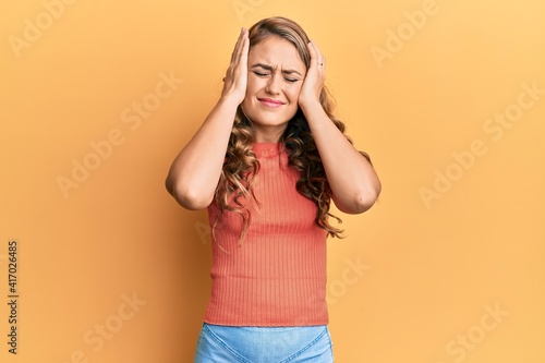 Young blonde girl wearing casual clothes suffering from headache desperate and stressed because pain and migraine. hands on head.