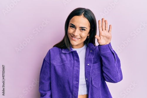 Young brunette woman wearing casual clothes waiving saying hello happy and smiling  friendly welcome gesture