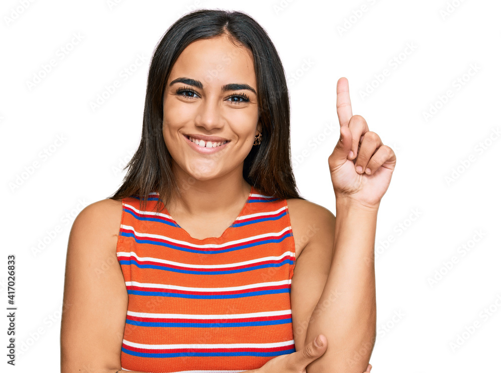 Young brunette woman wearing casual clothes with a big smile on face, pointing with hand and finger to the side looking at the camera. Young brunette woman wearing casual clothes with a big smile on face, pointing with hand and finger to the side looking at the camera.