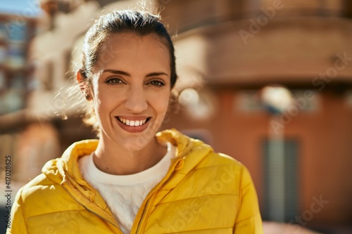 Young hispanic girl smiling happy standing at the city.