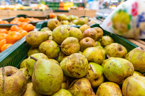 Green pears harvest. Fresh pears in a basket on shelf in supermarket close up photo