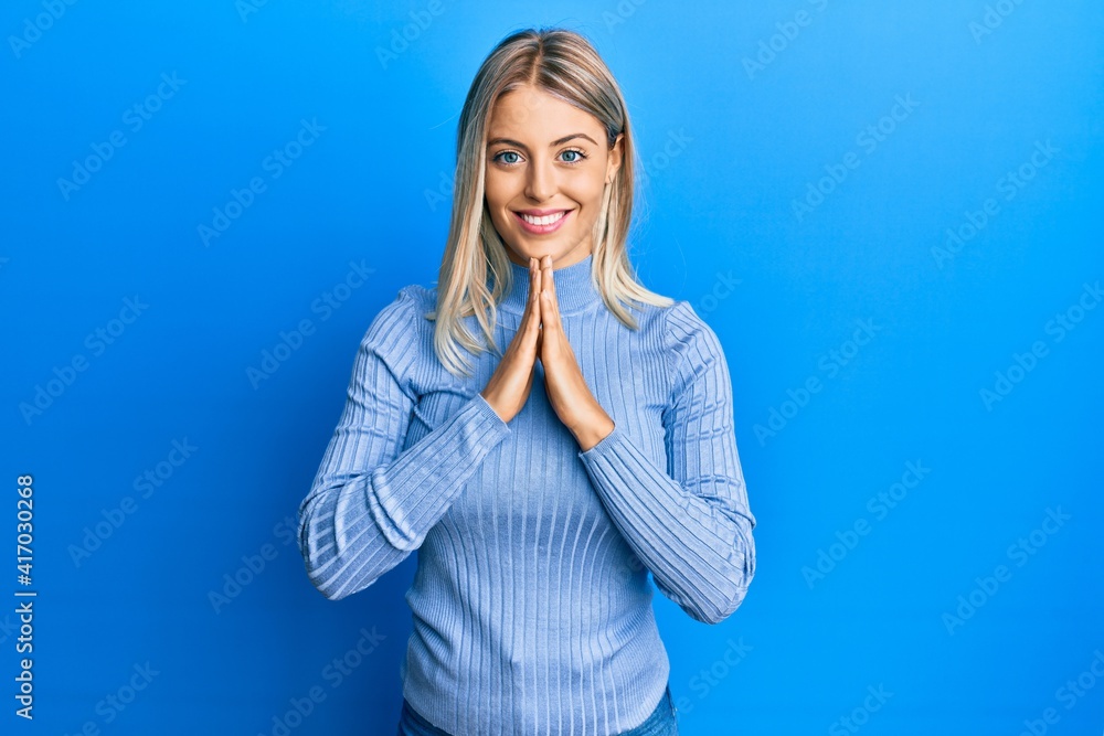 Beautiful blonde woman wearing casual clothes praying with hands together asking for forgiveness smiling confident. Beautiful blonde woman wearing casual clothes praying with hands together asking for forgiveness smiling confident.