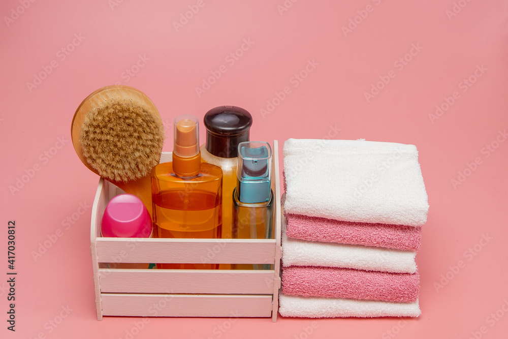 Flat lay composition with spa cosmetics and towel on pink background Flat lay composition with spa cosmetics and towel on pink background