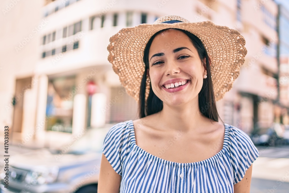 Young latin tourist girl on vacation smiling happy at the city.