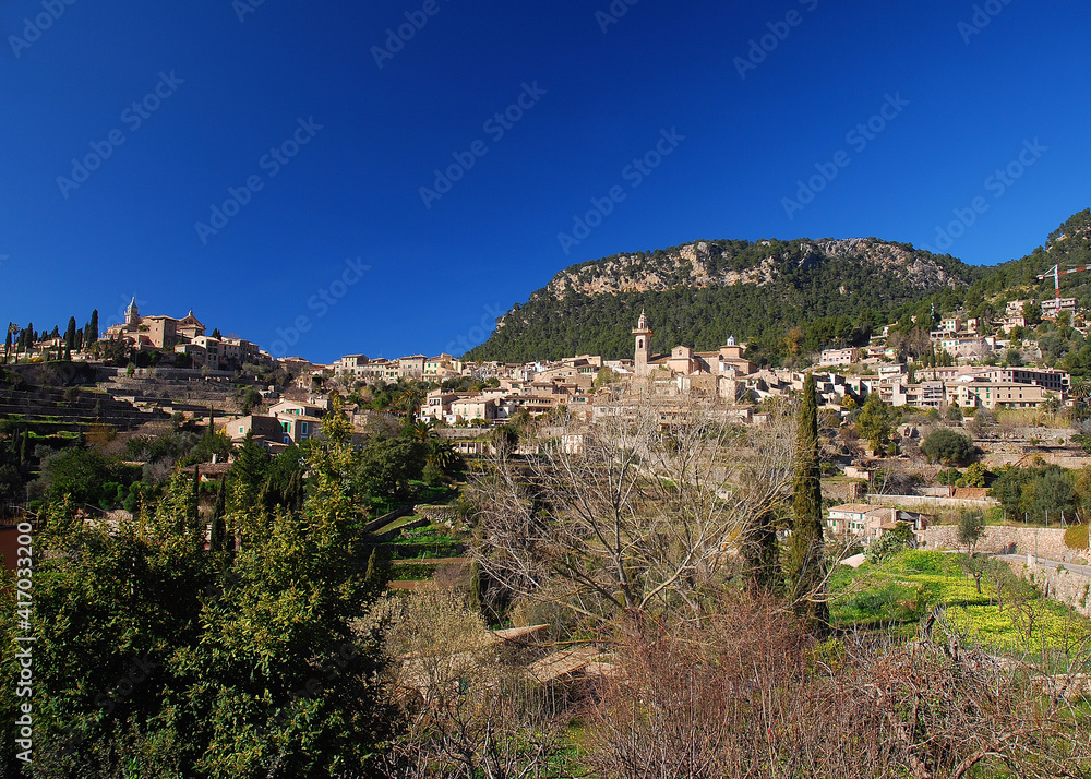 View To The Picturesque Village Of Valldemossa Within The Mountainous Landscape Of Tramuntana On Balearic Island Mallorca On A Sunny Winter Day With A Clear Blue Sky