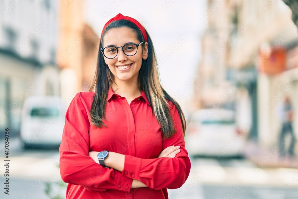 Young hispanic woman with arms crossed smiling happy at the city. Young hispanic woman with arms crossed smiling happy at the city.