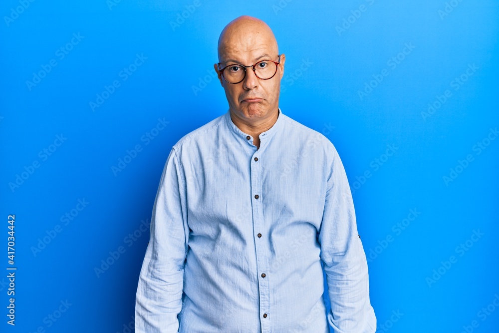 Fototapeta premium Middle age bald man wearing casual clothes and glasses depressed and worry for distress, crying angry and afraid. sad expression.