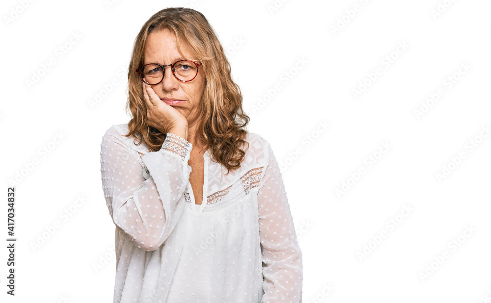 Middle age blonde woman wearing casual white shirt and glasses thinking looking tired and bored with depression problems with crossed arms.