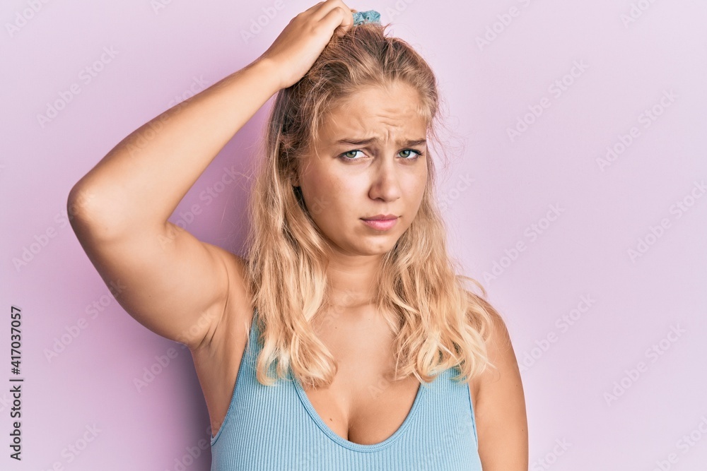 Young blonde girl wearing casual clothes confuse and wonder about question. uncertain with doubt, thinking with hand on head. pensive concept. Young blonde girl wearing casual clothes confuse and wonder about question. uncertain with doubt, thinking with hand on head. pensive concept.