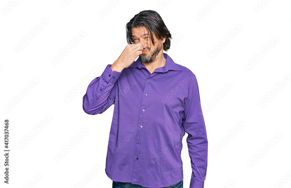 Middle age handsome man wearing business shirt smelling something stinky and disgusting, intolerable smell, holding breath with fingers on nose. bad smell Middle age handsome man wearing business shirt smelling something stinky and disgusting, intolerable smell, holding breath with fingers on nose. bad smell