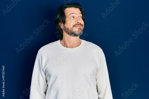 Middle age caucasian man wearing casual clothes smiling looking to the side and staring away thinking.